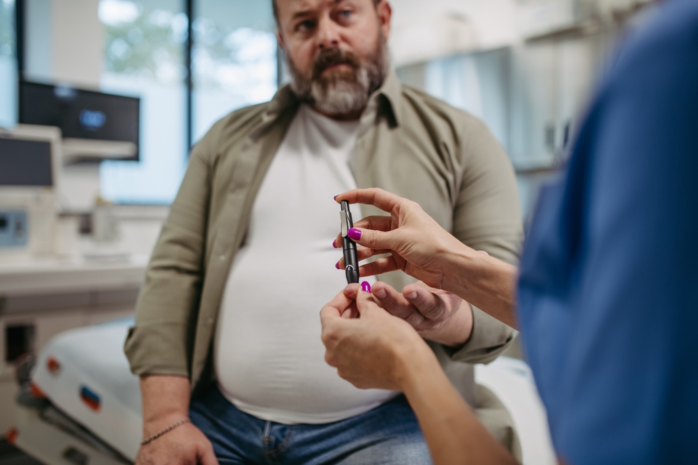 Home nurse,checking,man's,blood,glucose,level,using,a,fingerstick,glucose